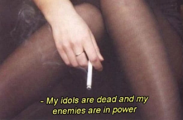 En hand som håller en cigarett, med texten: My idols are dead and my enemies are in power.